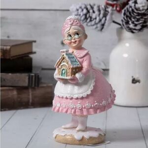 Mrs. Claus Holding Gingerbread House Pink and White Figurine